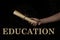 Education. Secondary and higher education concept. Vintage paper scroll on a black background.