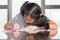 Educational back to school concept with elementary school Asian girl kid student studying doing homework writing on desk