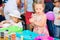 Educational circle for children. Group of nursery children sitting on chairs in their classroom. Male teacher, woman. shows how to