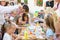 Educational circle for children. Group of nursery children sitting on chairs in their classroom. Male teacher, woman. shows how to