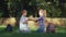 Educational games, scholar girl and boy playing clapping game sitting on lawn after schooling on school break