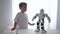 Educational toys, cute little boy repeats movements of robot with artificial intelligence close-up in room