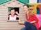 Educator with girl in playhouse in kindergarten