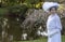 Edwardian woman in white lace outfit and large hat in a garden