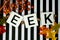 Eek Halloween phrase letters on fun black and white stripe background. Maple leaves and orange glittery stems for festivity. Use