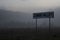 Eerie countryside landscape with signpost Zombie valley on the background of the evening misty forest