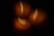 The eerie light of three candles in pitch darkness. Blurred digital illustration