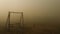 Eerie playground engulfed in thick toxic smog, swings cast shadows oblivion. Pollution