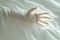 Eerie presence ghostly hand emerges from a white sheet background