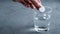 An effervescent aspirin tablet is thrown into a glass of water. Background with space for text