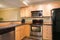 Efficient, compact kitchen design with honey stained kitchen cabinets