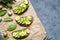 Egg and avocado sandwiches with guacamole, slice avocados, spinach, arugula and quail eggs on parchment paper for
