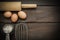 Egg beater, eggs on wooden table.