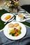 Egg Benedict slider with vegetable salad include tomato, potato, lettuce leaf and carrot with tea, coffee, and sweet melon served