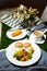 Egg Benedict slider with vegetable salad include tomato, potato, lettuce leaf and carrot with tea, coffee, and sweet melon served