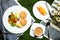 Egg Benedict slider with vegetable salad include tomato, potato, lettuce leaf and carrot with tea, coffee, and sweet melon served