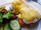 Egg Benedicts with Salmon served with cucumber and salad.