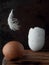 Egg and broken eggshell on wooden background. Feather flies over an egg. Close Up, Vertical orientation. Copy space