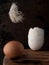 Egg and broken eggshell on wooden background. Feather flies over an egg. Close Up, Vertical orientation. Copy space