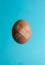 An egg of a broken shell on a light blue background with two patches. Creative Easter minimal concept.