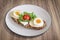 Egg And Cheese Sandwich With Lettuce And Cherry Tomato Served On Porcelain Plate Set On Walnut Wood Surface