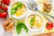 Egg cocotte in white ramekin with tomato and basil