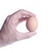 Egg between fingers. Concept of fragility