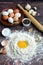 Egg in flour, rolling pin, eggs on a plate, bay leaf, salt and pepper on a dark wooden background