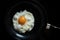 Egg fried on black pan in morning.Food and cooking concepts