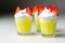 Egg liqueur in shot glass decorated with fluffy whipped cream and pieces of strawberry in the shape of bunny ears