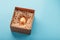 Egg made of gold in a wooden box on a blue background. The concept of exclusivity and superprize. Minimalistic composition