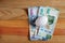 Egg and Mexican banknotes on wooden table.