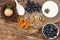 Egg in a nest, blueberries, flour in bowl, dried apricot, nuts, cinnamon sticks and anise on wooden background