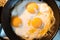 Egg omelette is being prepaired in a frying pan close up - Three yellow eggs in Eastern Europe Latvia Riga