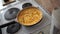 Egg omelette in the hands of the cook in the home kitchen, against the background of a white electric stove.