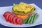 Egg omelette on a piece of fried bread with green beans, red tomato and carrot on a plate, close up. Breakfast concept