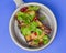 Egg-plant rolls with meat and pomegranate seeds served in a bowl over blue background