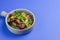 Egg-plant rolls with meat and pomegranate seeds served in a bowl over blue background