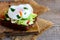 Egg poached sandwich. Egg poached on rye bread slice with fresh vegetable salad. Healthy sandwich photo. Wooden background