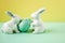 Egg with rabbits figurines on a bright background. Bird spotted eggs. Several objects. Healthy food. Easter holiday