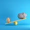 Egg and rock playing on yellow seesaw on blue background