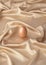 Egg on a satin beige background. Egg painted with face powder. Easter 2021 concept