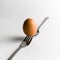 A egg that is set on the top of two forks. Eggs have so many uses from dieting to making recipes for baking.