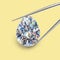 Egg shaped diamond held in Tweezers Yellow Backround