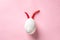 Egg shell and red hot chilli pepper imitation rabbit, hare face of devil clown on pink colored background paper. Food concept mini