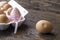 Egg tray on a wooden table with an egg decorated with an Easter ribbon another egg is split and lies separately