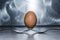 Egg on two forks against stainless steel brushed background