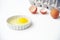 Egg yoke with egg shells and egg carton in white background
