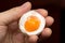 Egg with yolk in a hand