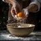 Egg yolk in the hands of the cook on a black background